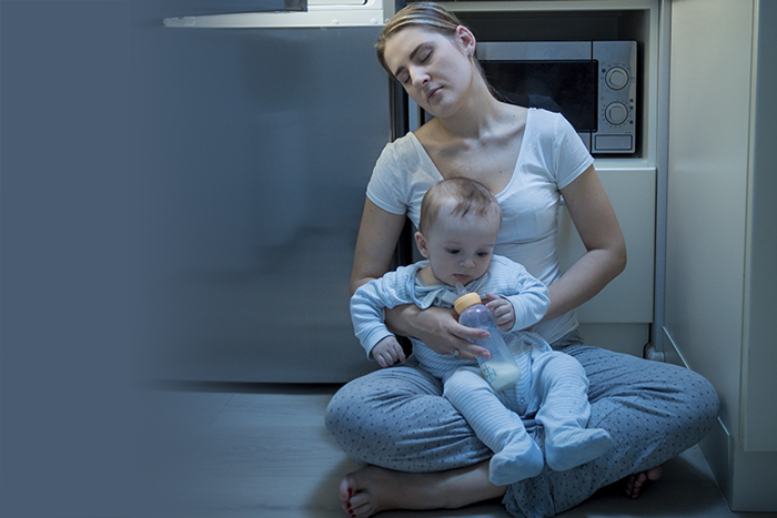 mom sleeping in kitchen with baby