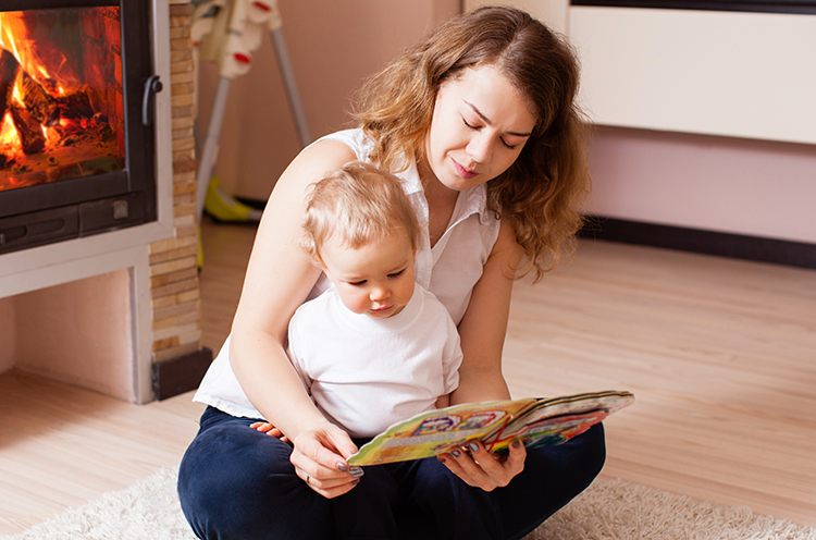 mom reading story book to baby