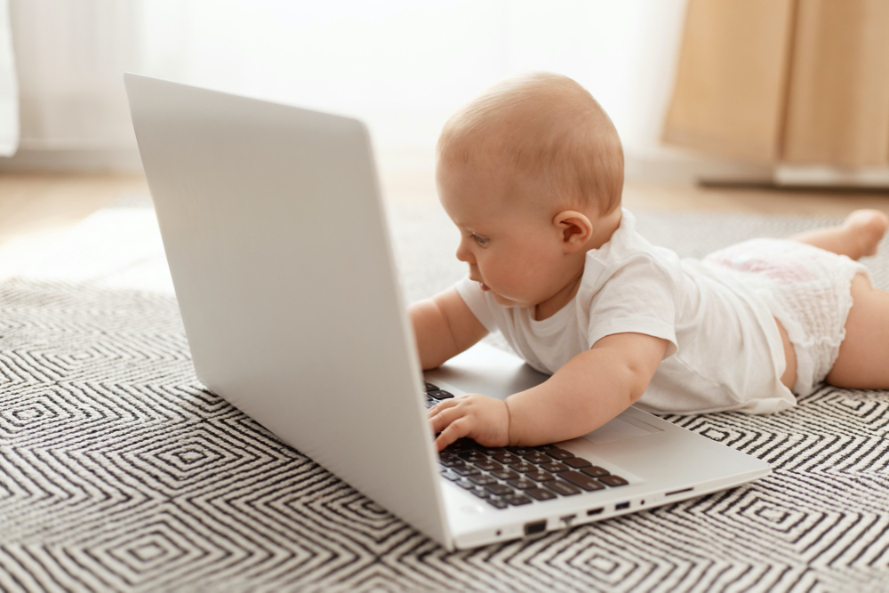 baby boy playing with laptop