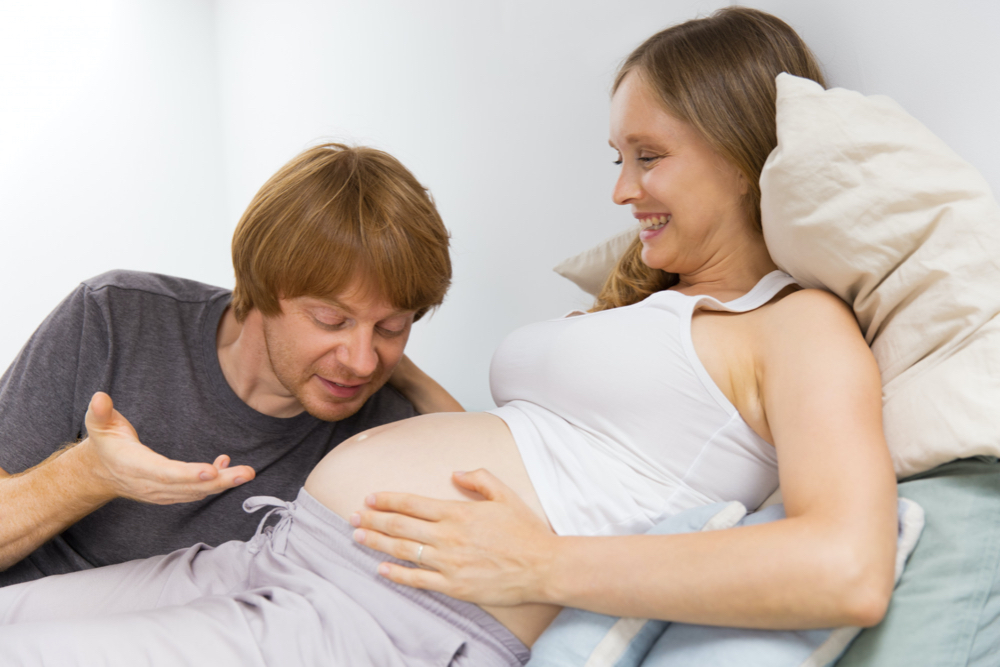 dad talking to pregnant mom's belly